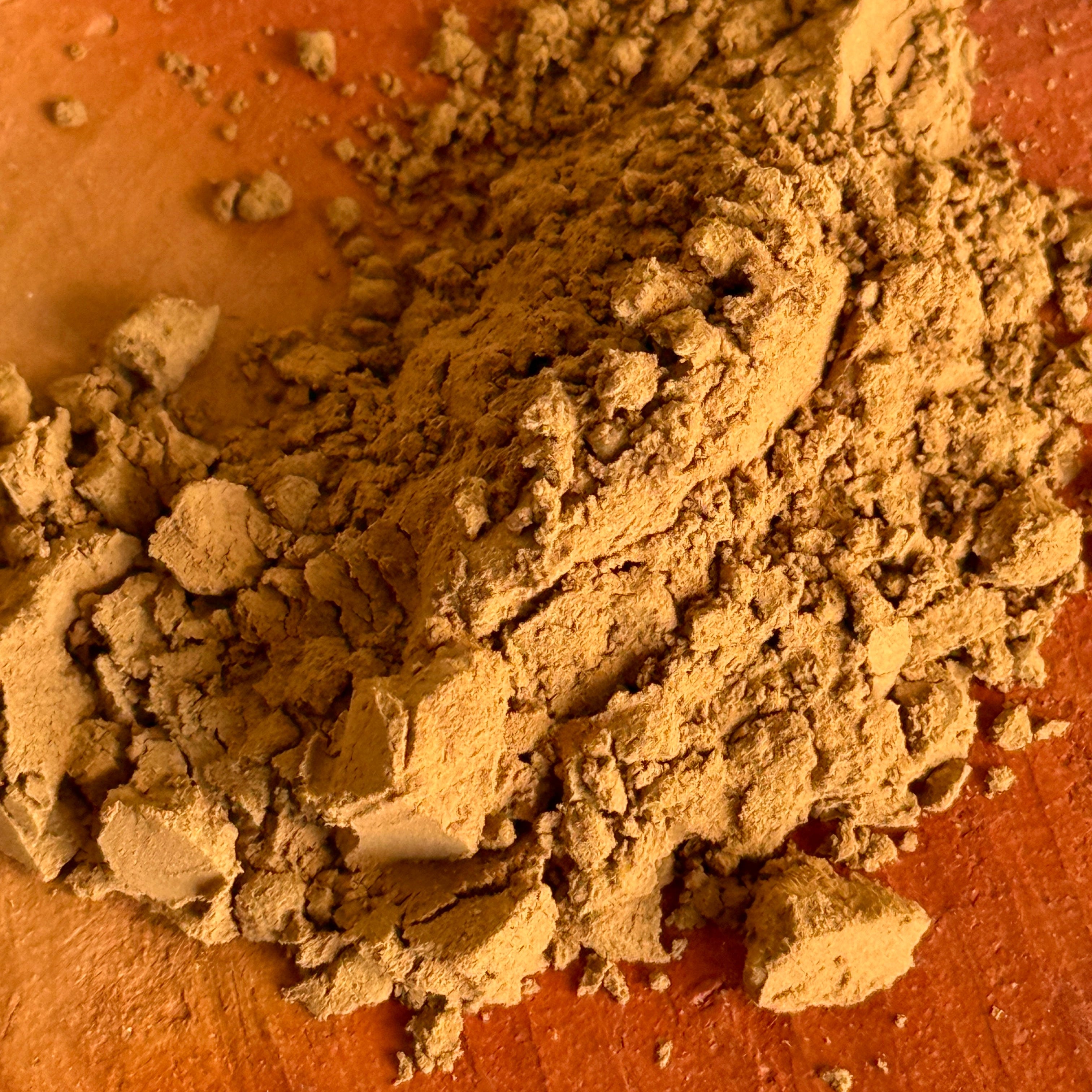 Micro-ground roasted green tea powder known as Japanese Hojicha on a clay plate. 