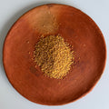 Brown plate with a roasted buckwheat seeds from Japan lay on a light gray background