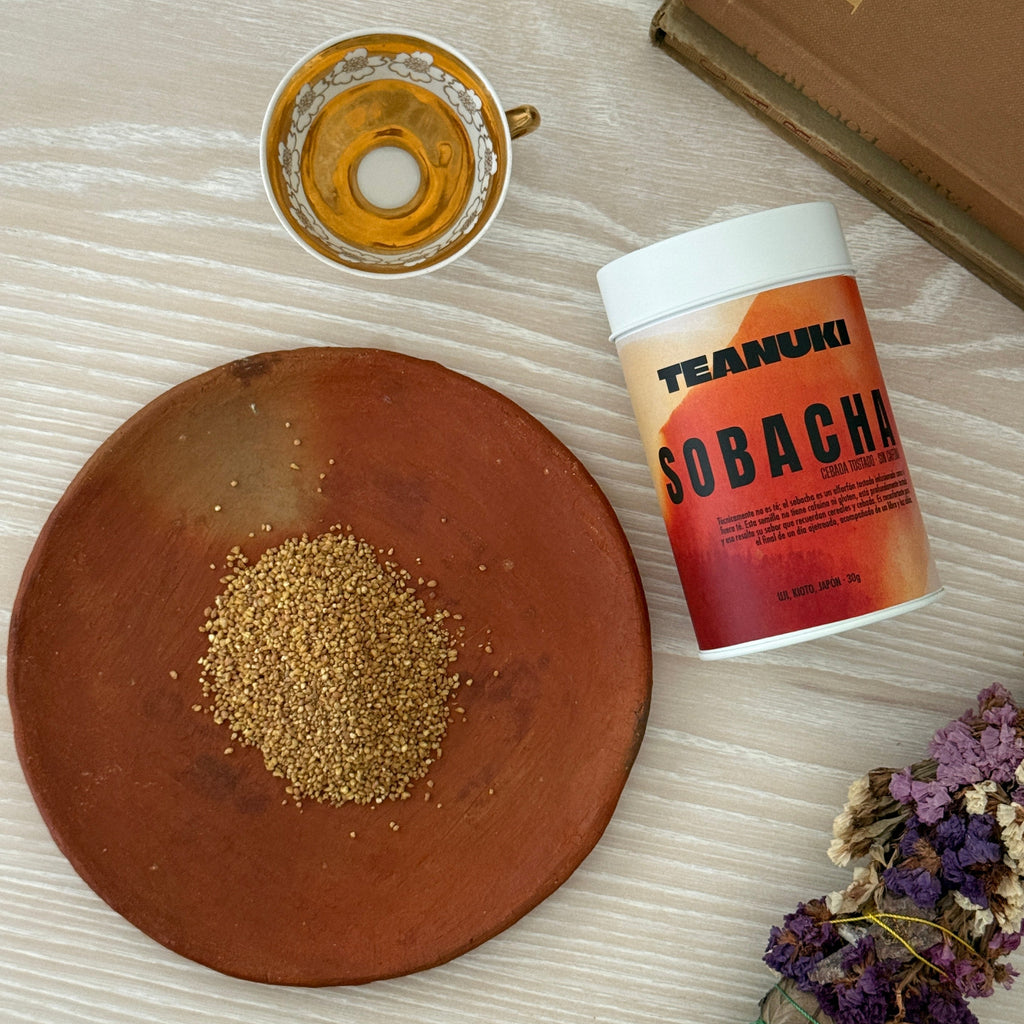 A plate with roasted Japanese buckwheat and tin of Sobacha from Teanuki on a white wood table. 