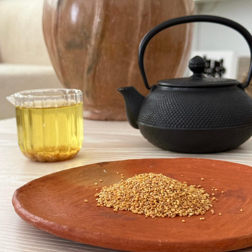 Tea-making setup with a black ironteapot, plate with sobacha, and glass of brewed tea, infused Japanese tartary buckwheat from Teanuki. 