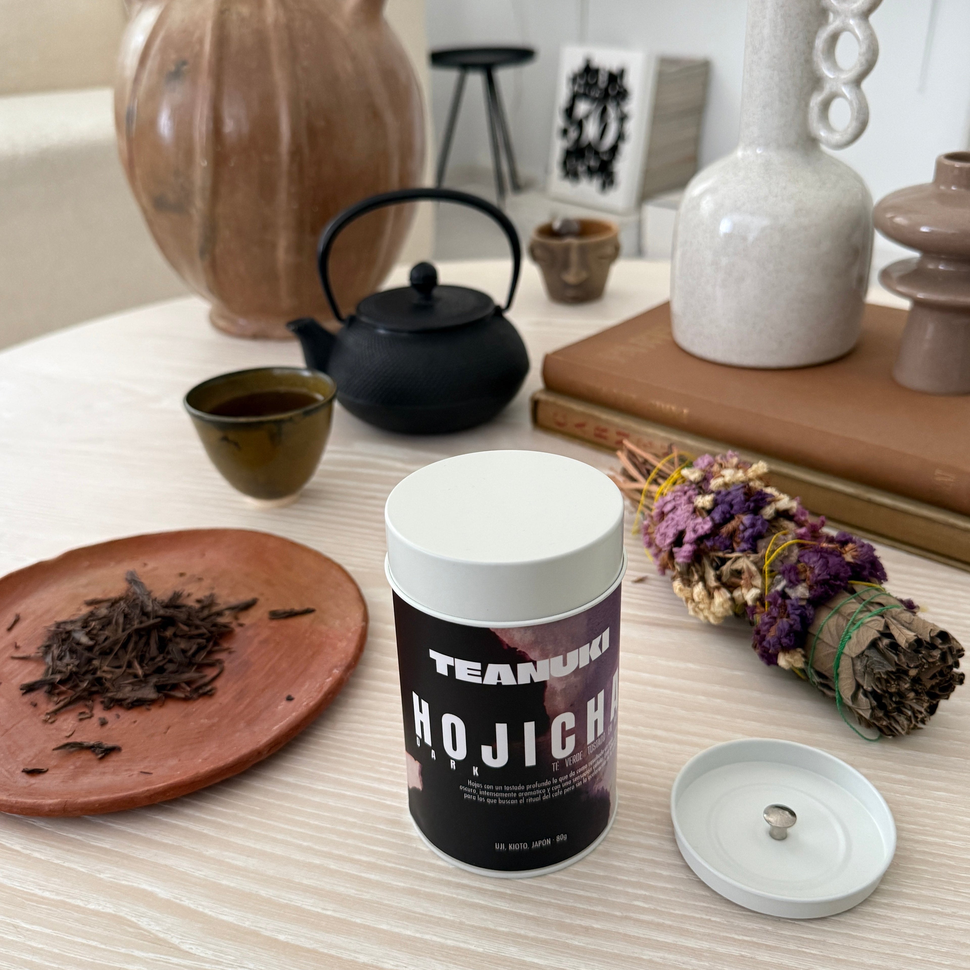 Teanuki Dark Roast Hojicha Tea packaging on a wooden surface with decorative items